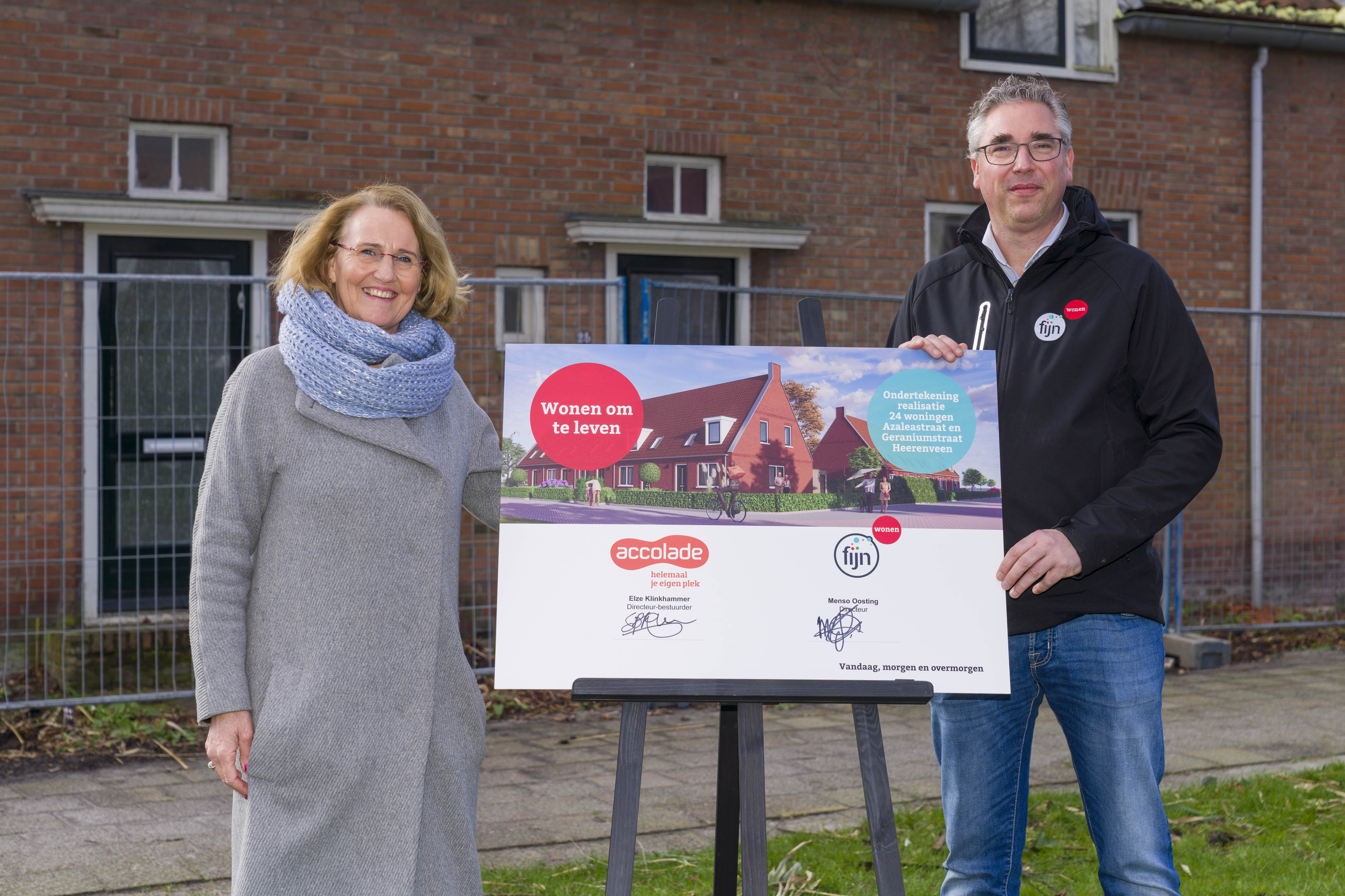 Elze Kllinkhammer van Accolade en Menso Oosting van Fijn Wonen bij het bord met de ondertekening van het project aan de Azaleastraat in Heerenveen