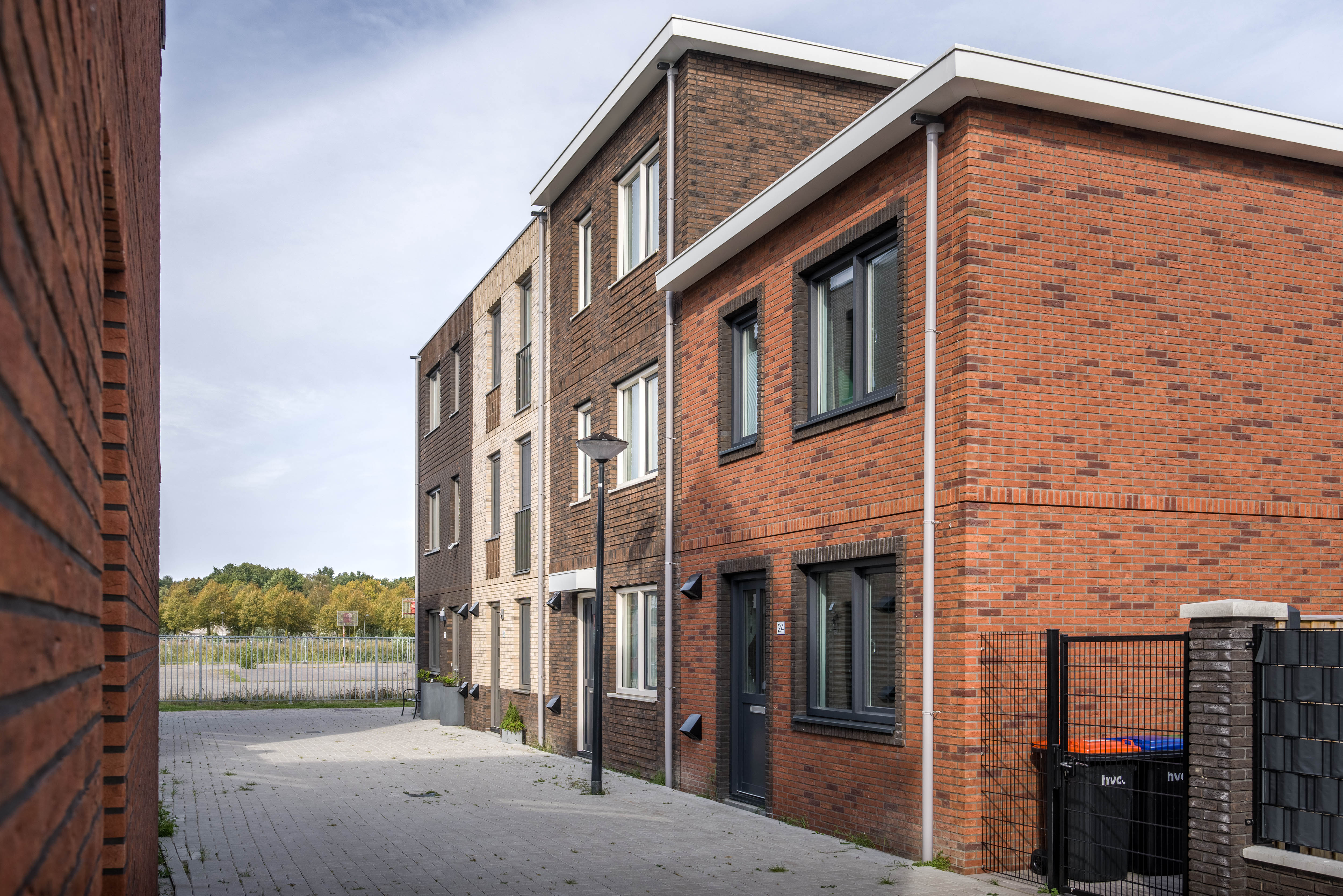 Straat met 4 woningen van verschillende typen. 3 woningen met 3 etages en 1 woning met 2 etages.