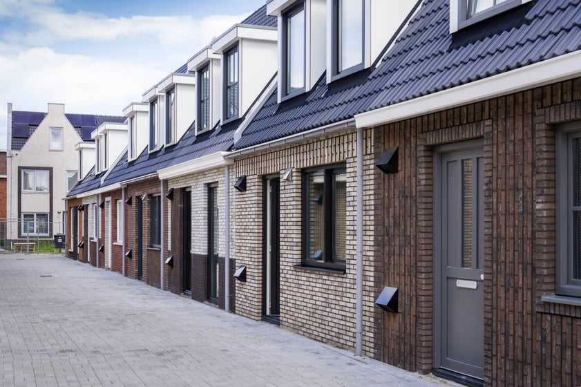 Je ziet een straatje met eenlaags met kap woningen met allemaal een ander gevel ontwerp
