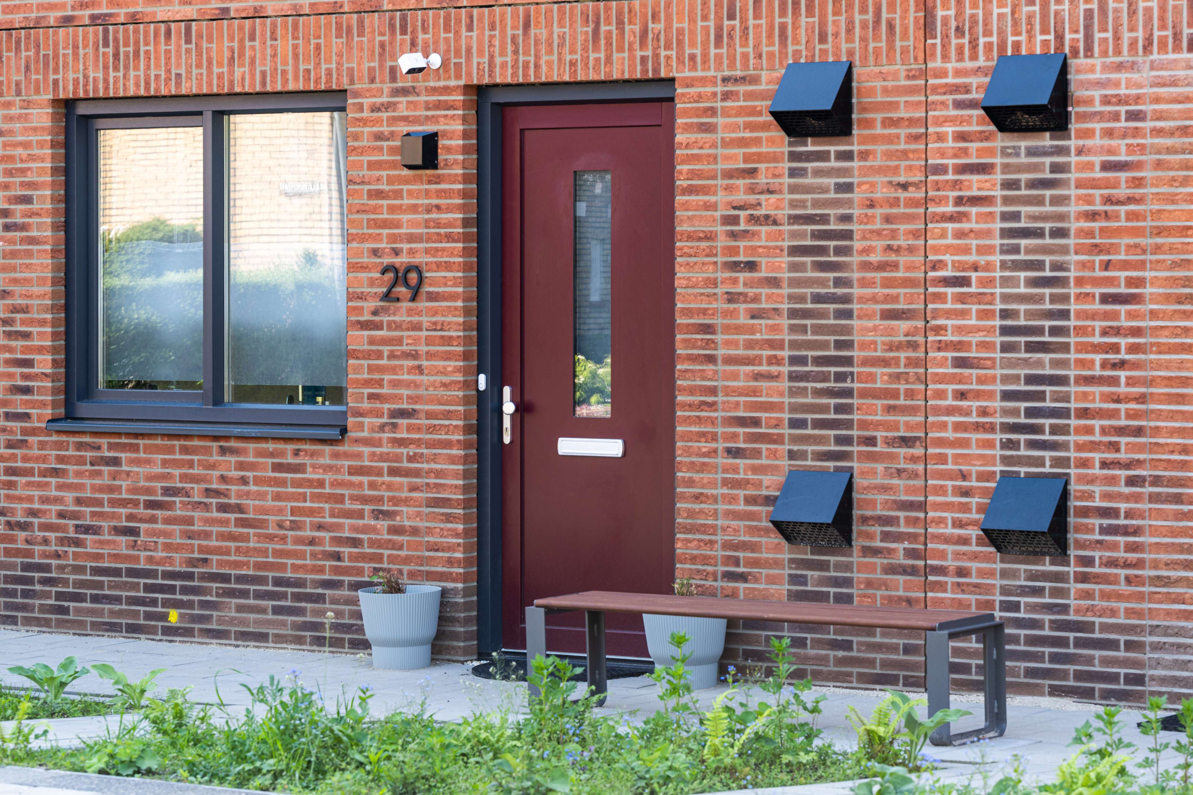 Voorgevel van nieuwbouwwoningen in Mariaberg Maastricht met bakstenen muur en entree