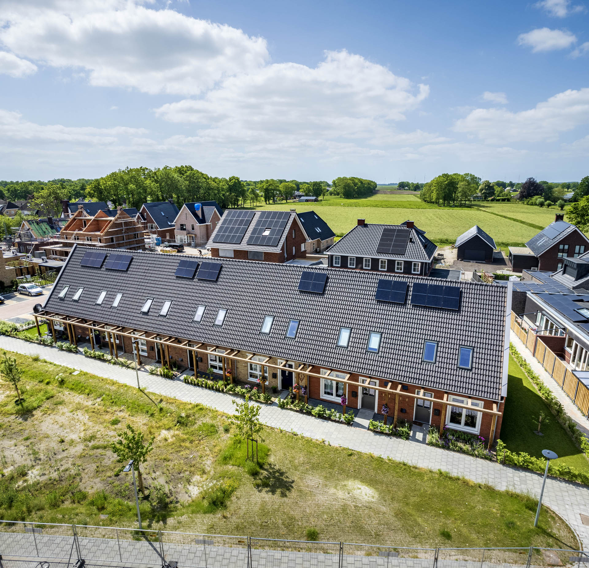 Dronefoto van de eenlaags met kap woningen met maatwerk Pergola in Oosterwolde