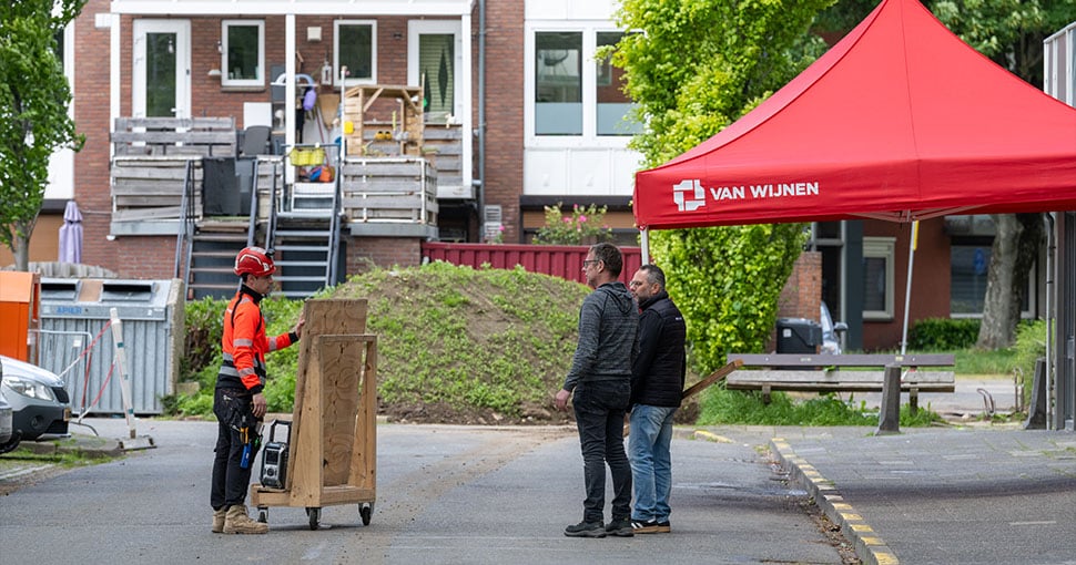Collega in gesprek met bewoners Martin Luther Kingplein flat Geleen