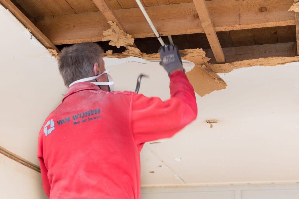 Bouwer bezig met werkzaamheden aan het plafond