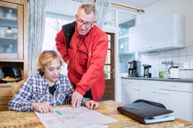 Medewerker geeft uitleg aan bewoner