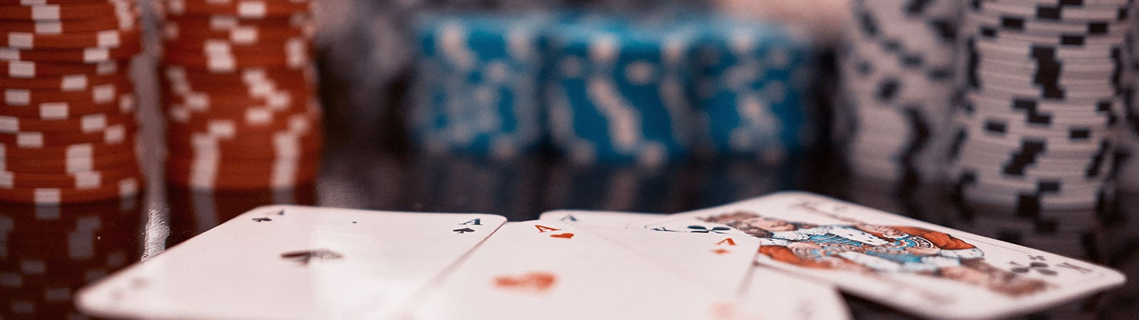 Close-up view of two aces, one of spades and one of hearts, on a blurred casino table backhround