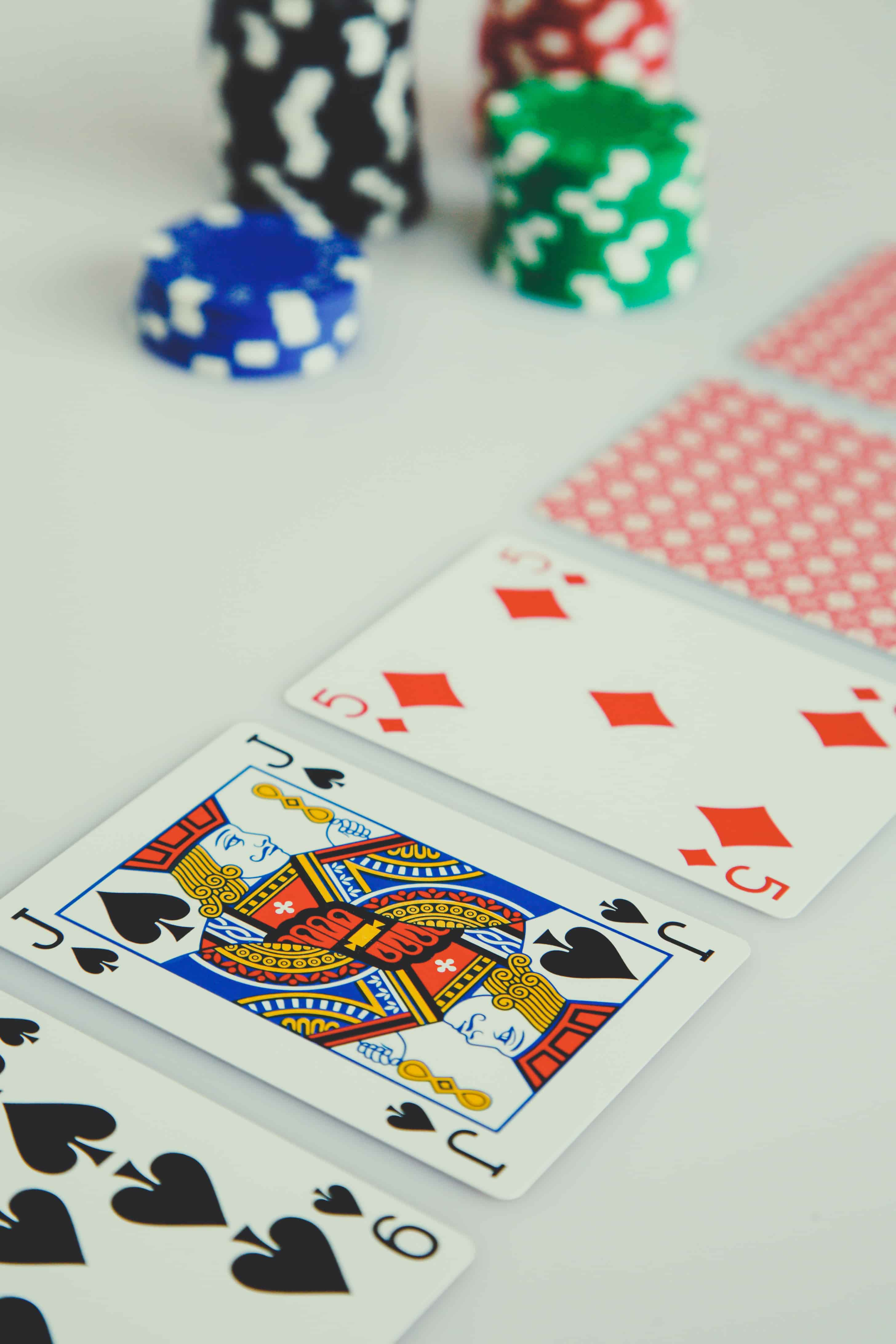 Jack of Spades, Five of Diamonds, and Six of Spades playing cards with poker chips in the background