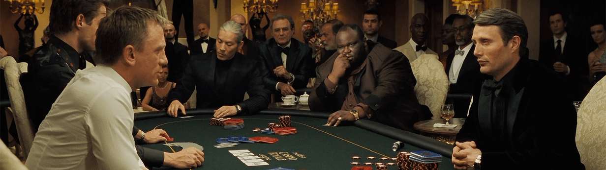 A group of people playing poker at a green felt table in an elegant, dimly lit room with stacks of red, blue, and white poker chips in front of each playerpoker