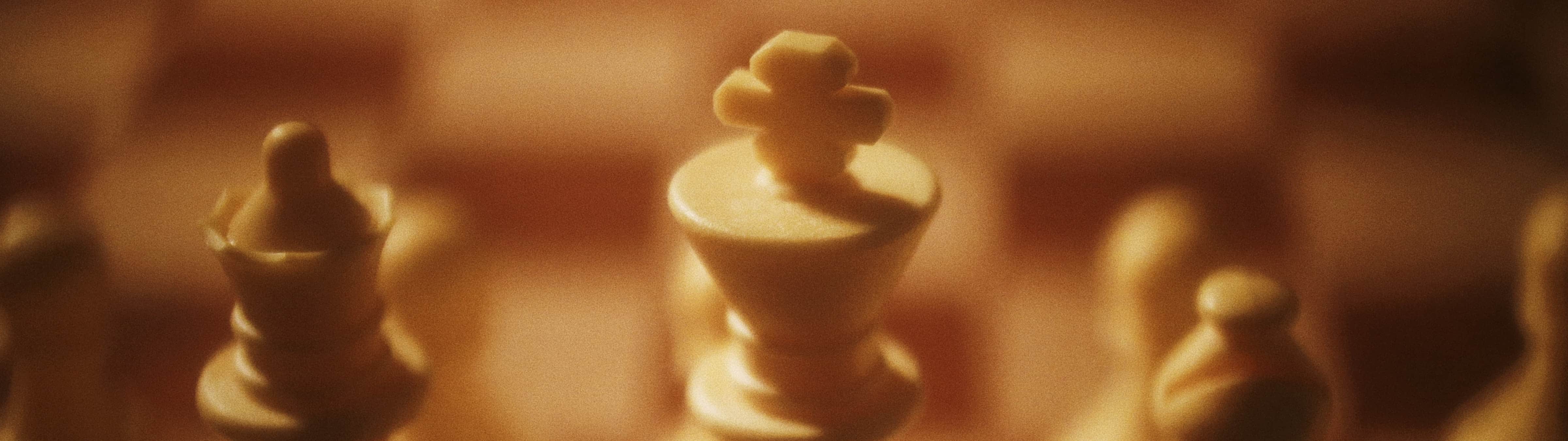 Close-up view of chess pieces, with a king in focus, illustrating strategic thinking and competition