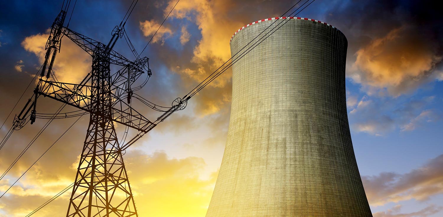 Nuclear, clean energy cooling tower next to electric power lines