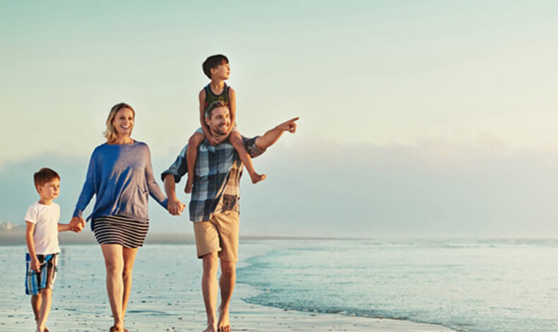 family walking along beach 