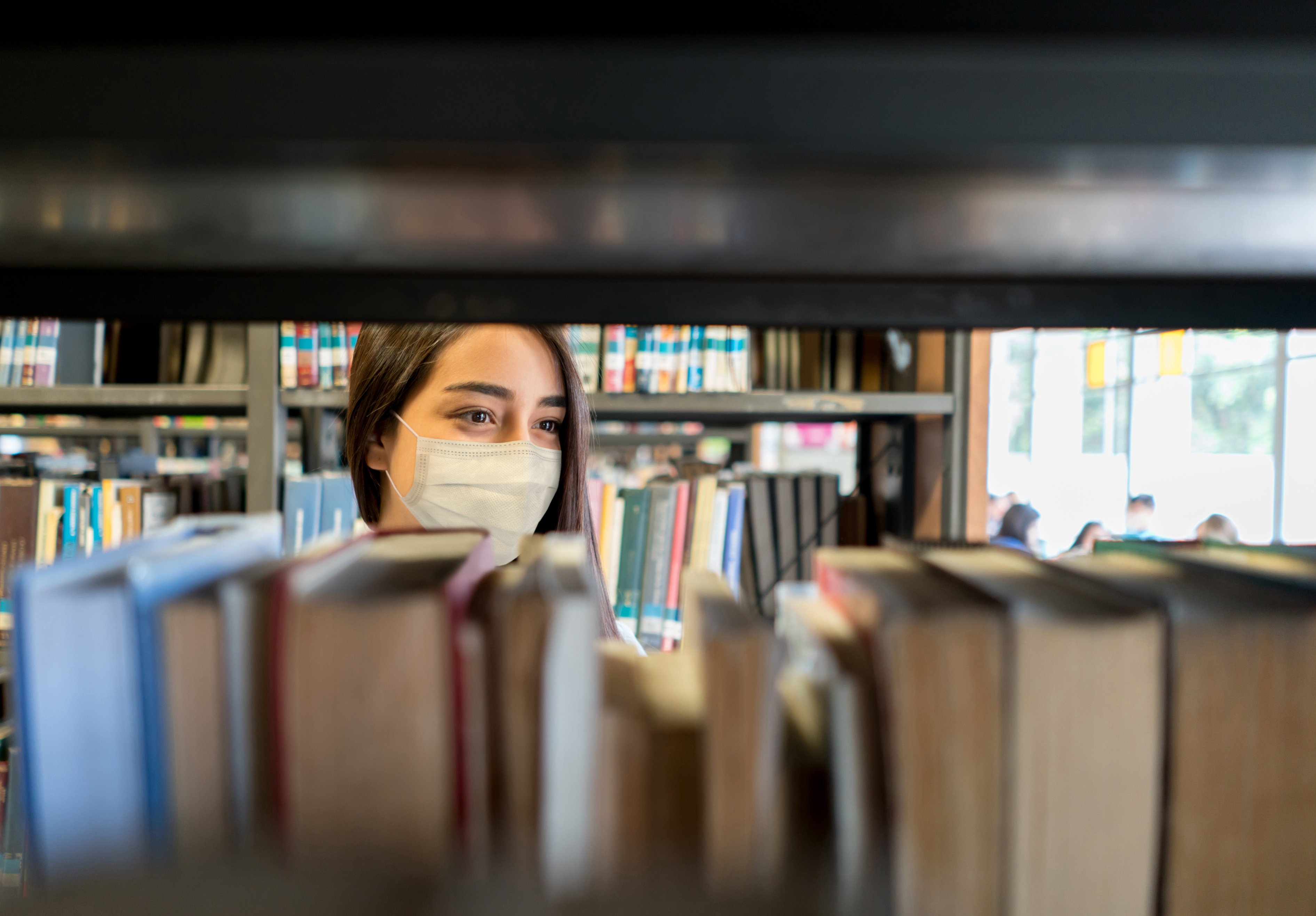 Woman looking at books in a library 