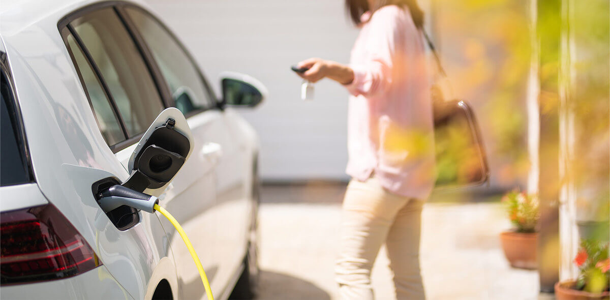 A woman locks her electric vehicle remotely