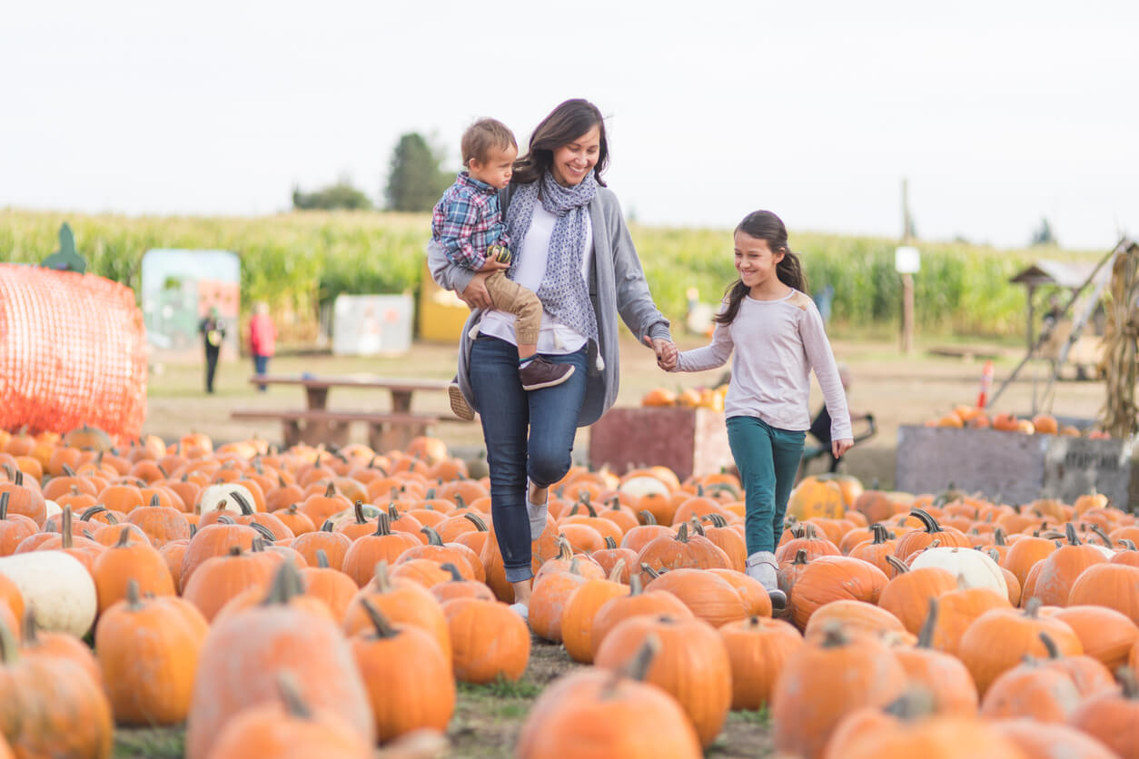 Mother walking with children through pumpkin patch