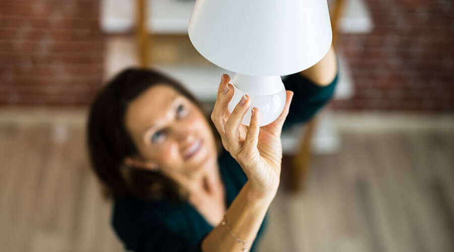 Woman installing an energy efficient light bulb