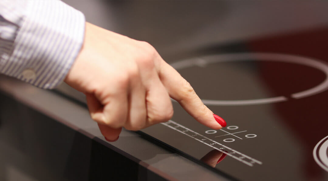 A woman’s hand turns on a stove