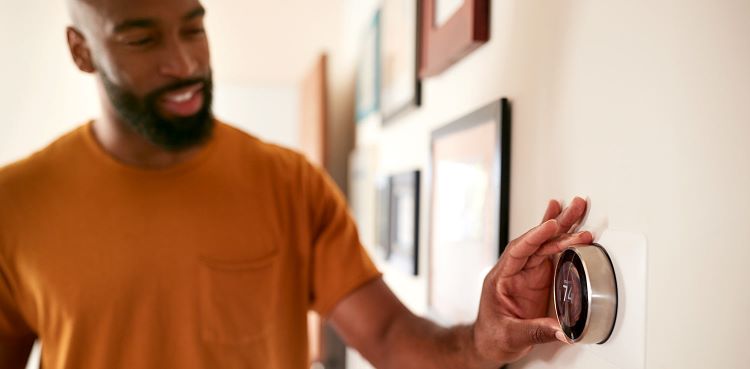 Man setting smart thermostat features