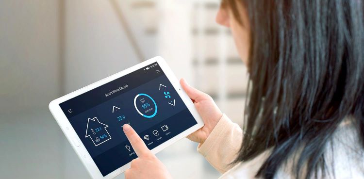 Woman programs smart thermostat with digital tablet