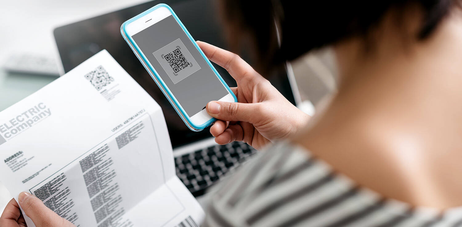 Woman checks her energy bill with a smartphone.