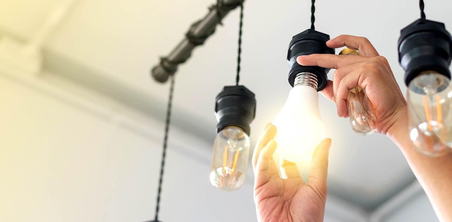 Person screws in an LED light bulb.