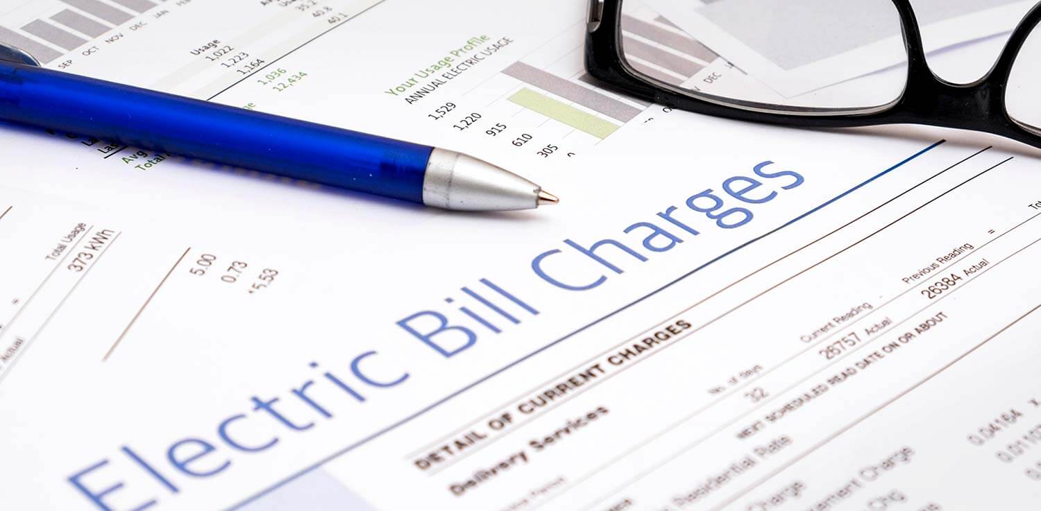 Pen and glasses resting on report of electricity usage and fees