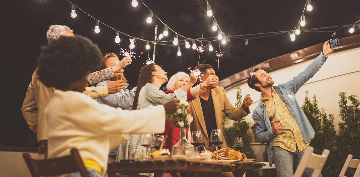 A group of friends celebrate at an outdoor nighttime patio party