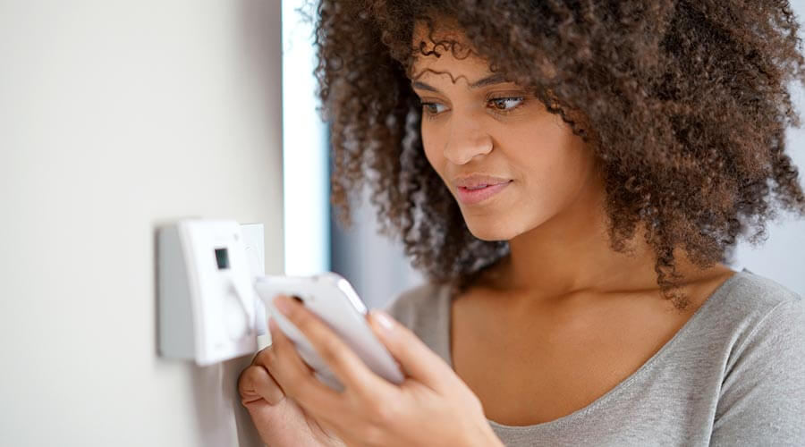Woman setting thermostat