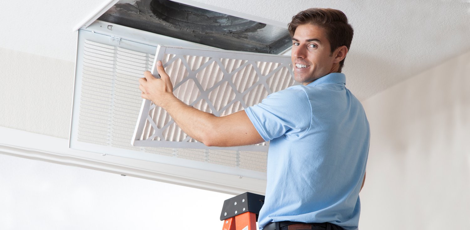 man cleaning AC filter