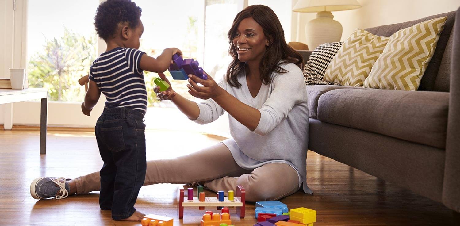 Mother-and-toddler-play-with-toys-in-living-room