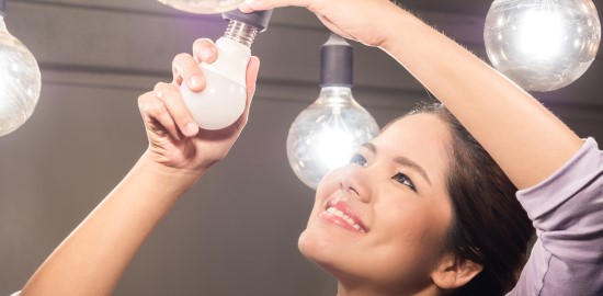 Smiling woman changing a light bulb