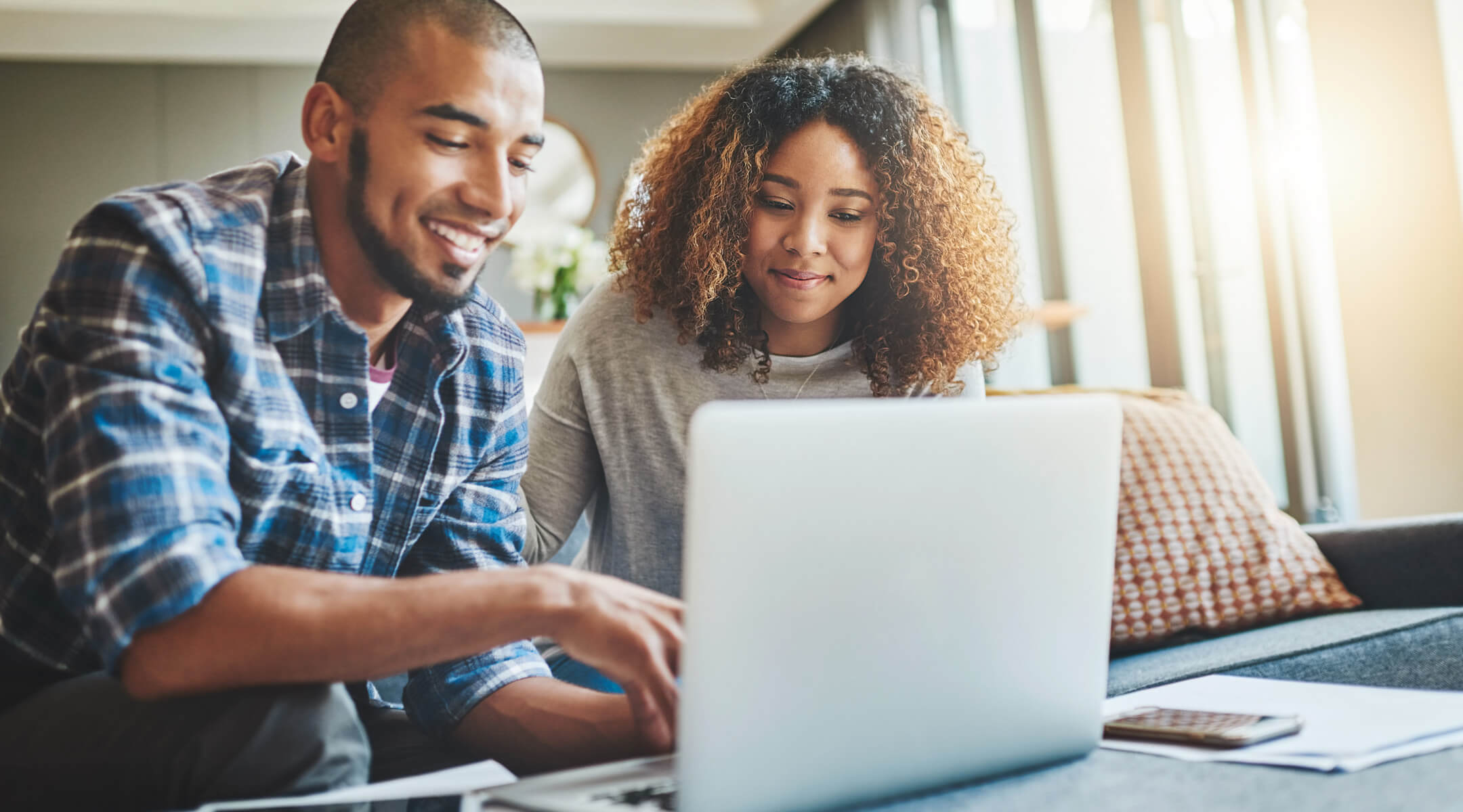 A couple looks at a laptop monitor