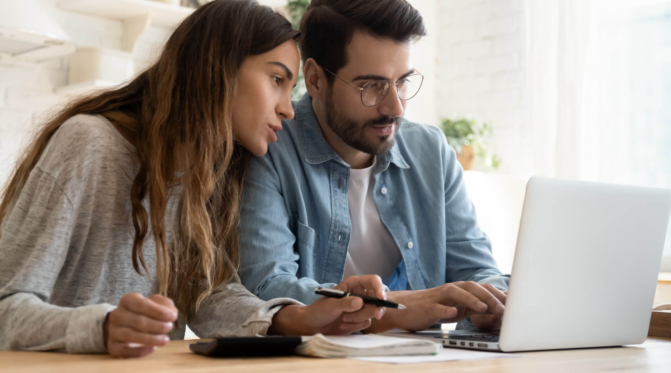 A couple looks at a laptop monitor