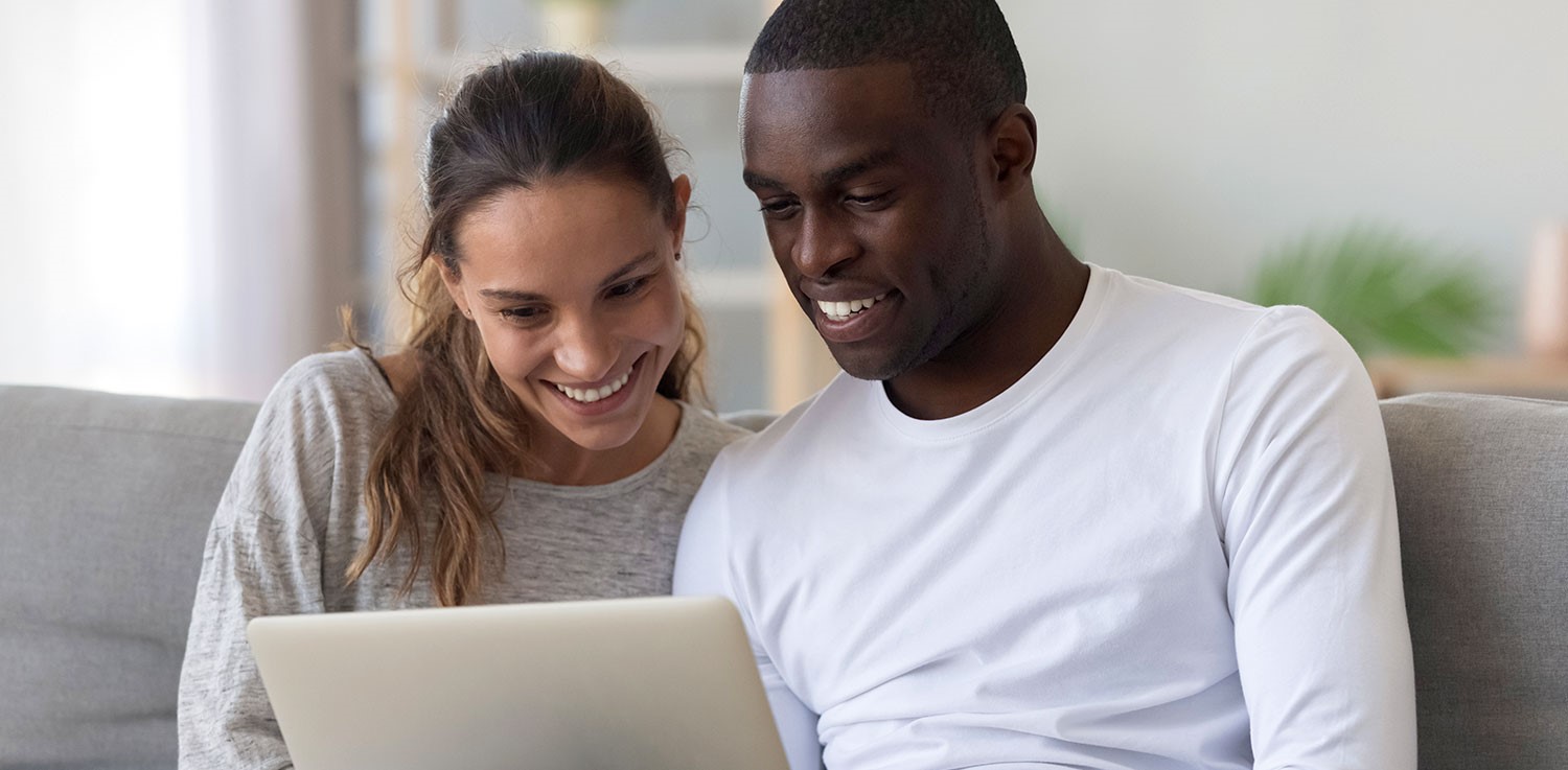 A couple looks at information on a laptop