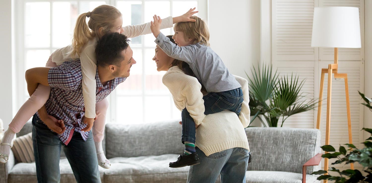 A mother and father play with their two children, a girl and a boy