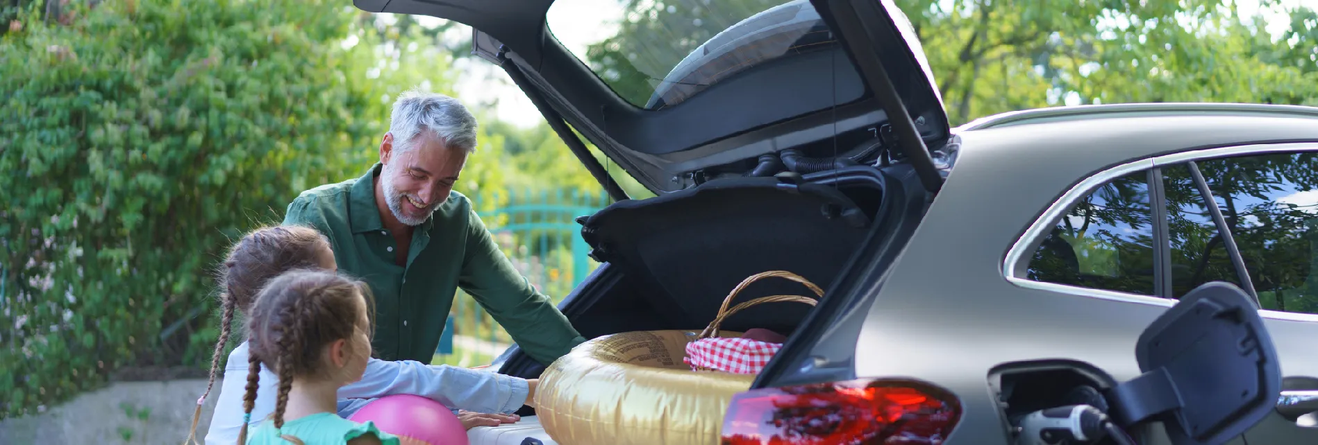 Man laadt auto in samen met kinderen - Private lease of kopen met financiering.