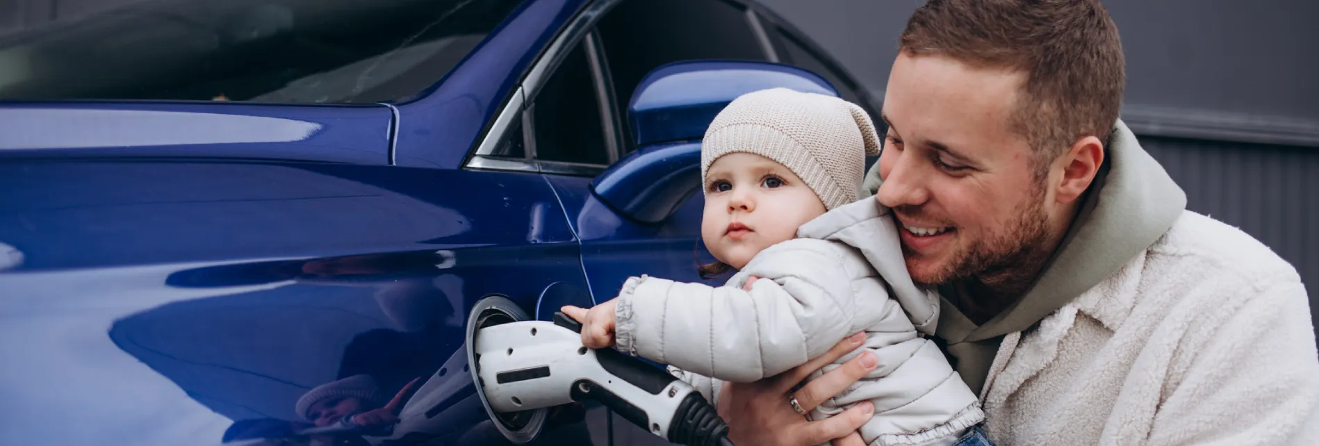 Vader stopt samen met kind de stekker in een elektrische auto