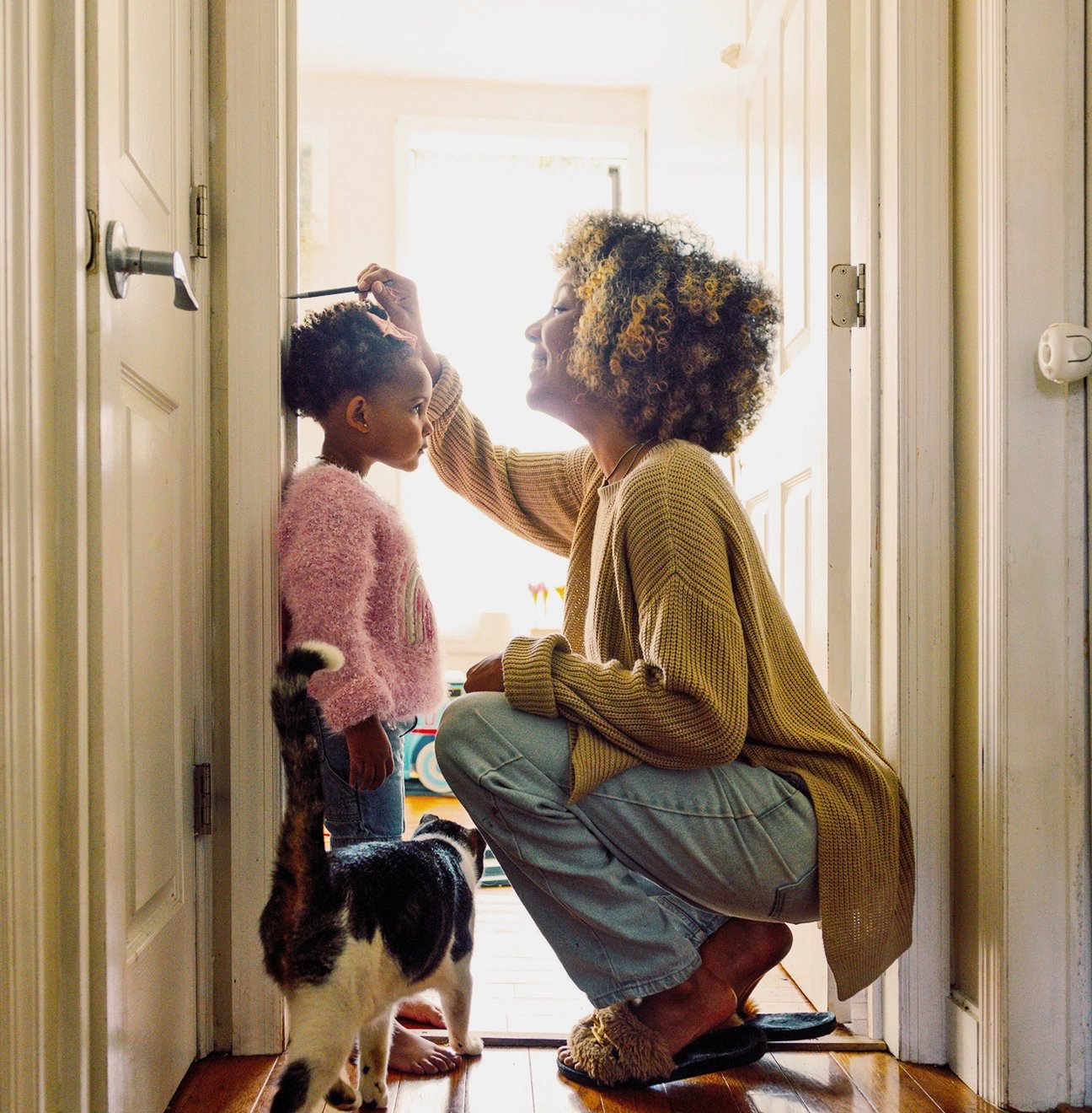 A young mother measures her small child against the door frame, confident because she purchased family term life insurance.
