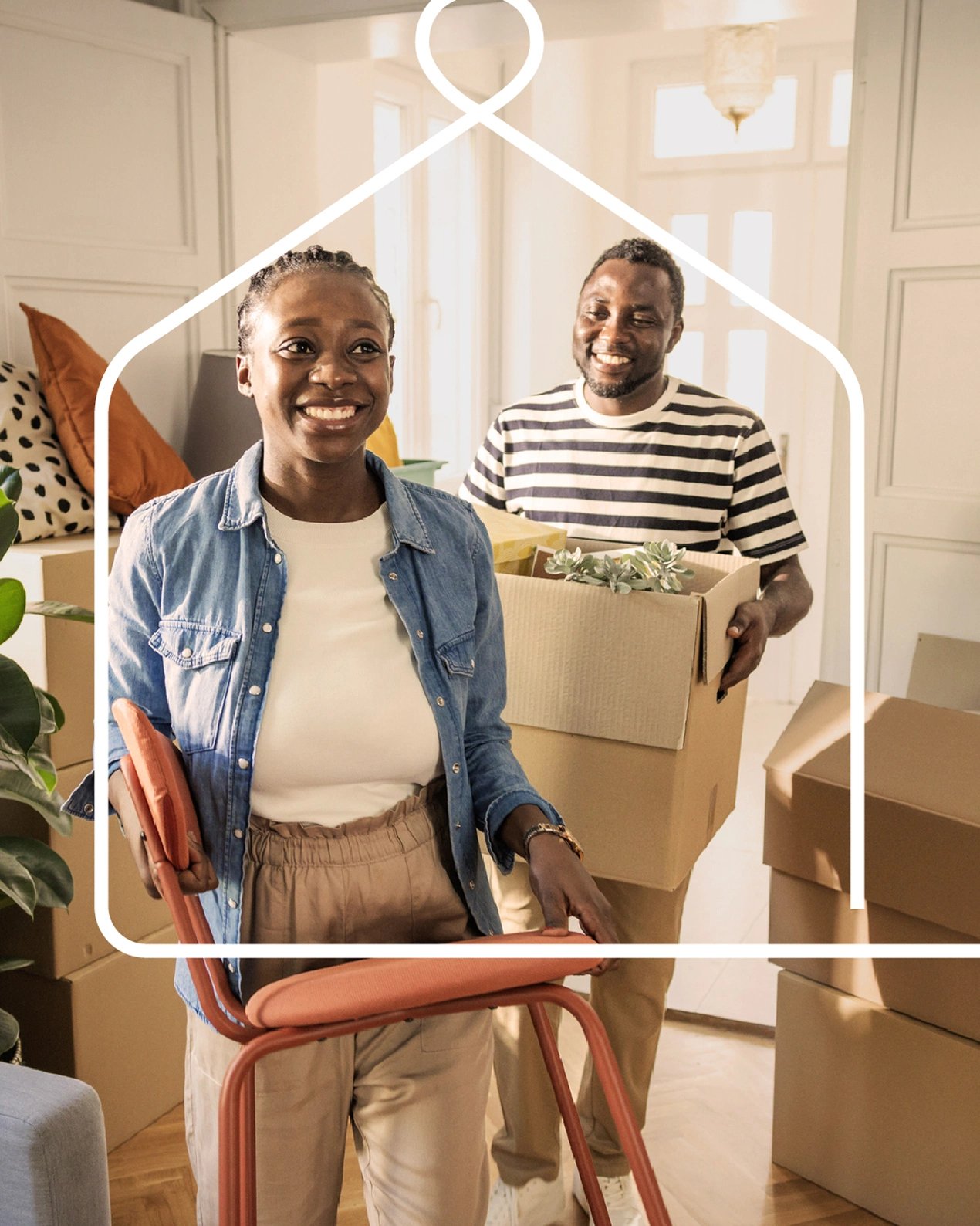 A happy young couple carries boxes and furniture into their new home.