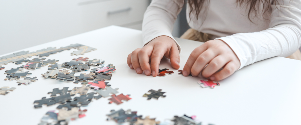 child putting together a jigsaw puzzle