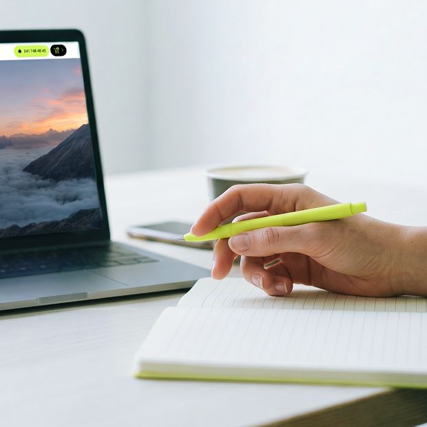 Person arbeitet mit Laptop, Notizblock und Stift