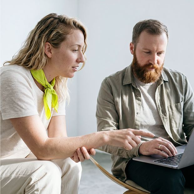 Zwei Geschäftskunden besprechen gemeinsam Inhalte auf einem Laptop