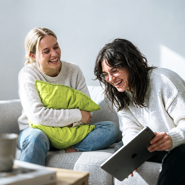 Zwei Frauen schauen gemeinsam Inhalte auf einem Tablet an
