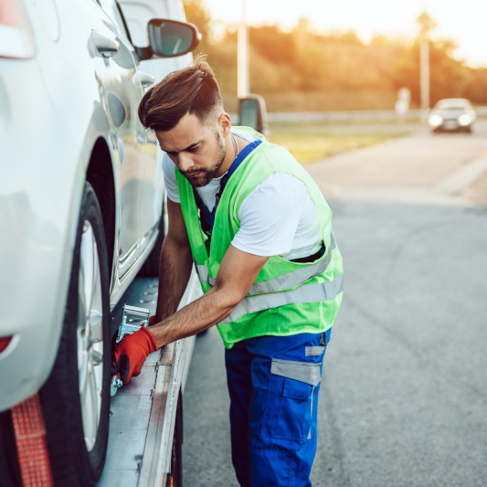man-ties-car-on-tow-truck