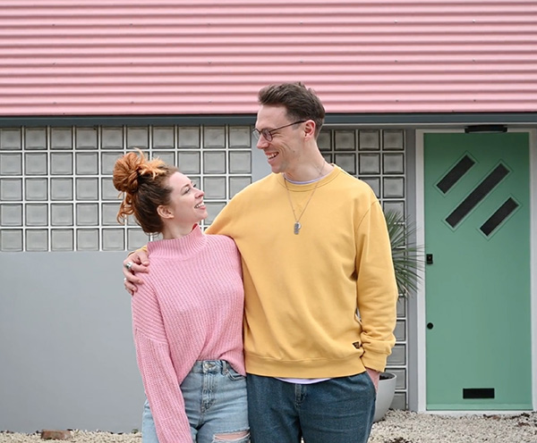 man and woman in front of a house