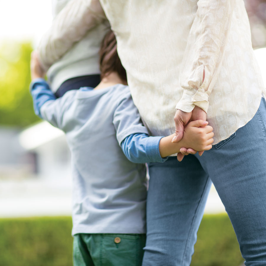 back of mother holding childs hand