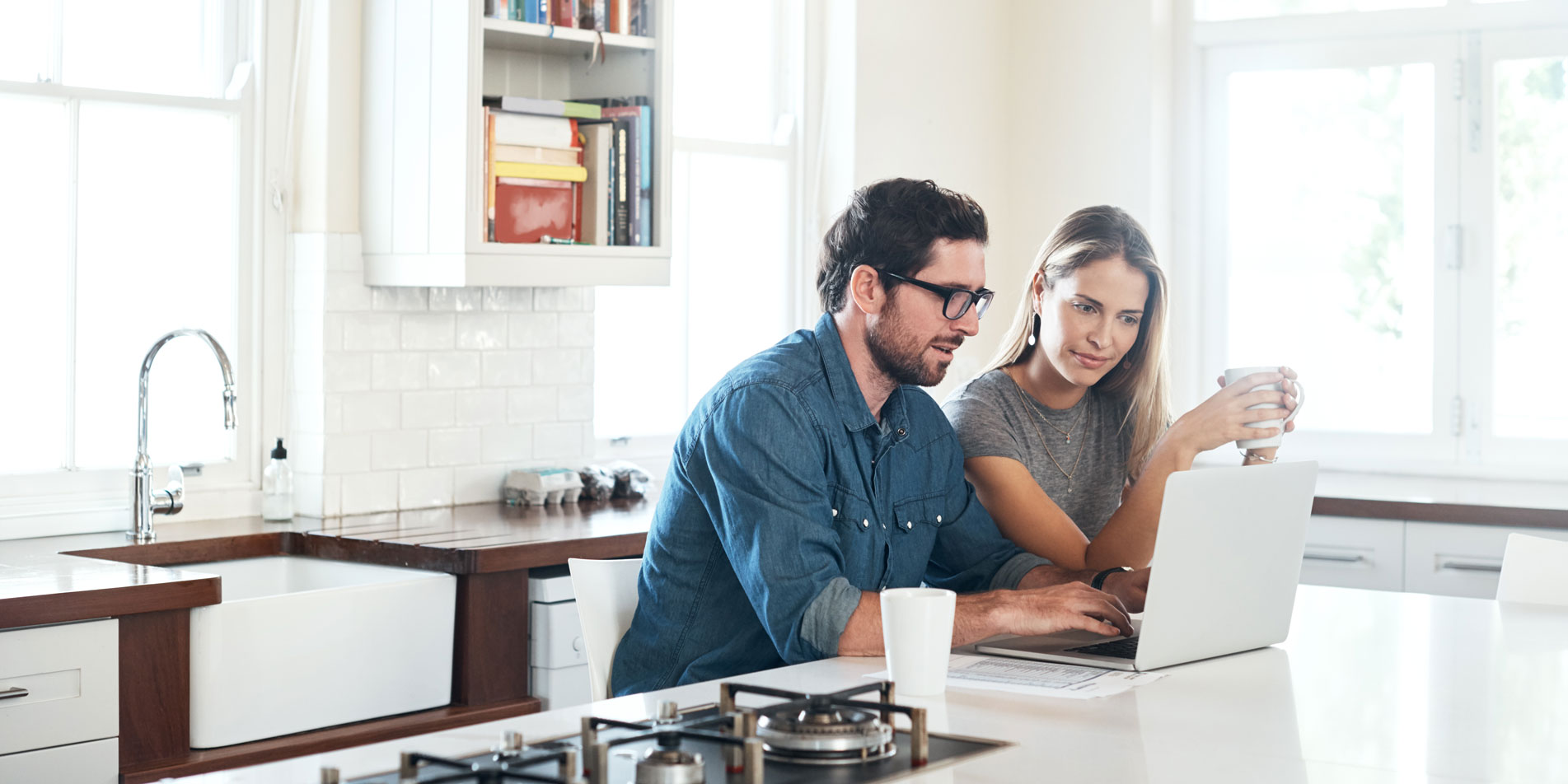 couple in the kitchen looking at laptop