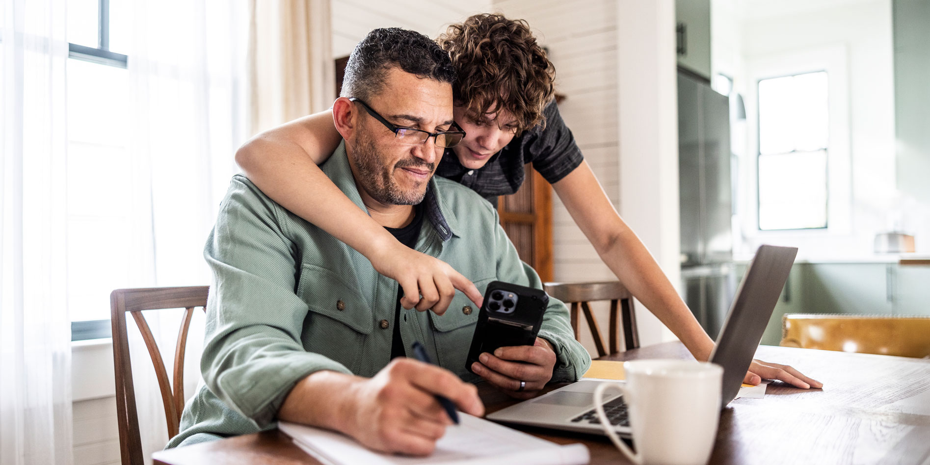 father and son looking at mobile phone