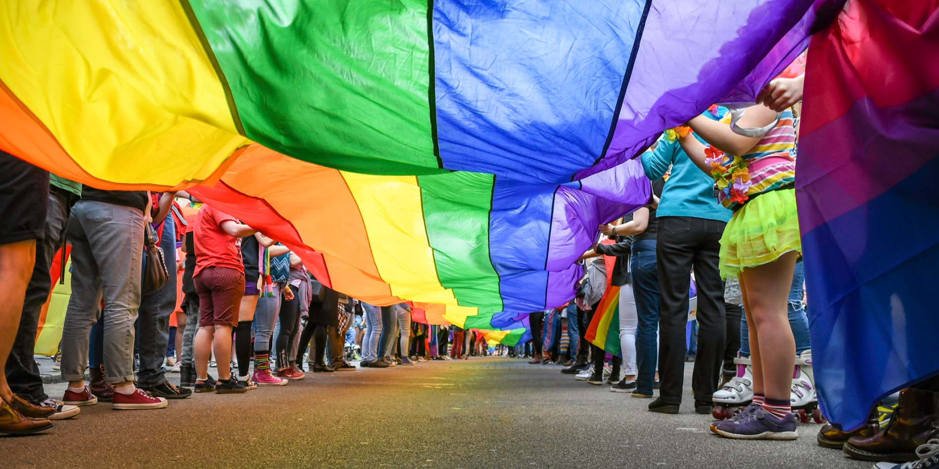 People waving Rainbow Pride Flag