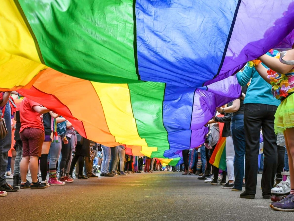 People waving Rainbow Pride Flag