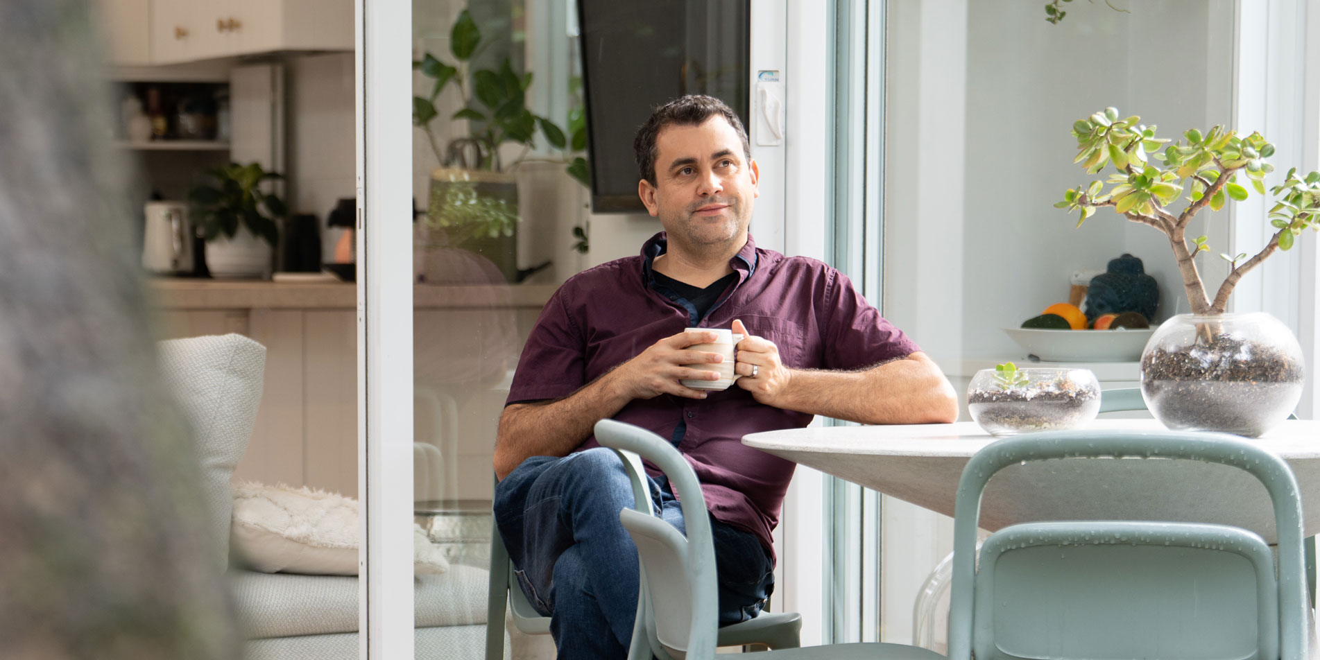man sitting at table with mug of coffee
