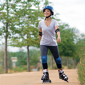 Woman rollerblading with helmet and knee pads
